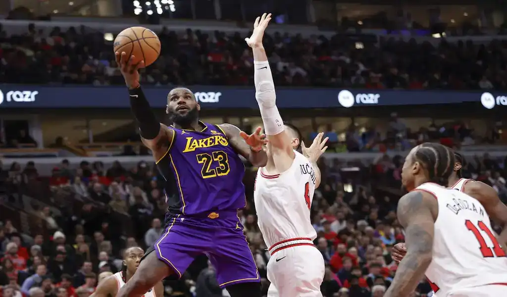 Los Angeles Lakers player driving to the basket against Chicago Bulls defenders during an NBA game.