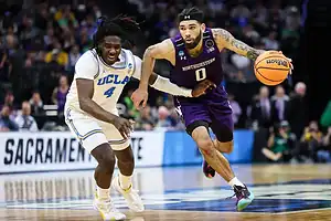 Northwestern basketball player driving past UCLA defender during an NCAA tournament game.