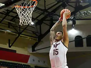 Virginia Tech basketball player rises up for a two-handed dunk inside the paint.