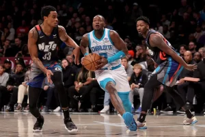 charlotte hornets player running from 2 rival players