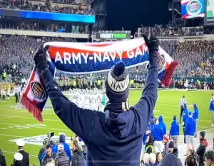 A Navy fan holds up an “Army-Navy Game” scarf at a packed football stadium during the annual rivalry game on December 9, 2023.