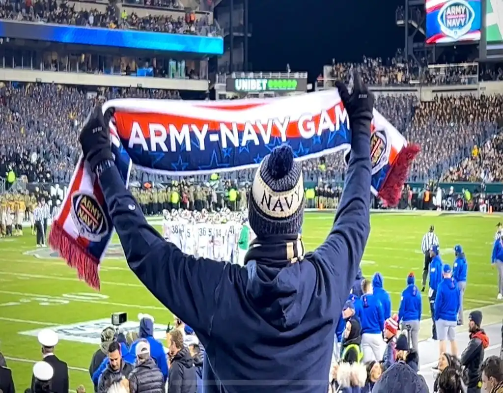 A Navy fan holds up an “Army-Navy Game” scarf at a packed football stadium during the annual rivalry game on December 9, 2023.