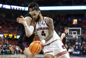 An Auburn player drives aggressively toward the basket while being closely guarded by a defender