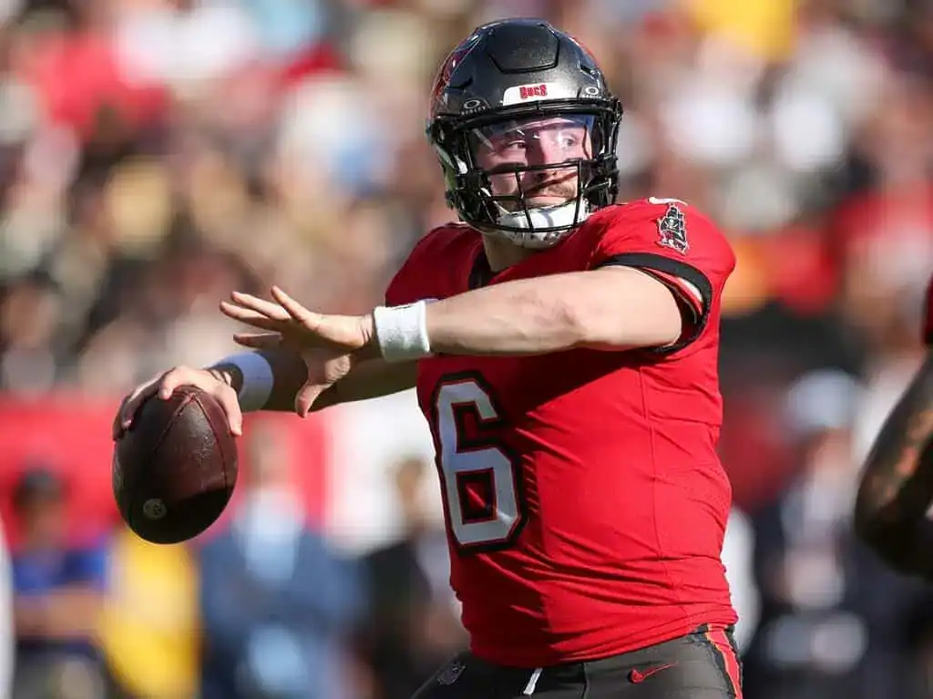 Tampa Bay Buccaneers quarterback winding up to throw a pass during an NFL game, wearing a red jersey and black helmet.