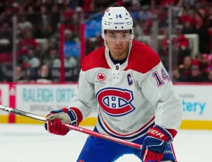 Montreal player focused and gripping his hockey stick likely preparing for a play