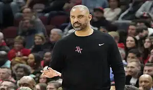 Houston Rockets coach giving instructions courtside during an NBA game against the Boston Celtics on January 13, 2024.