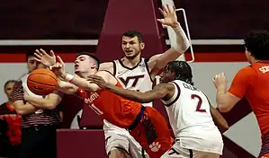 Clemson Tigers guard drives to the basket against Boston College Eagles defense during NCAA basketball action.