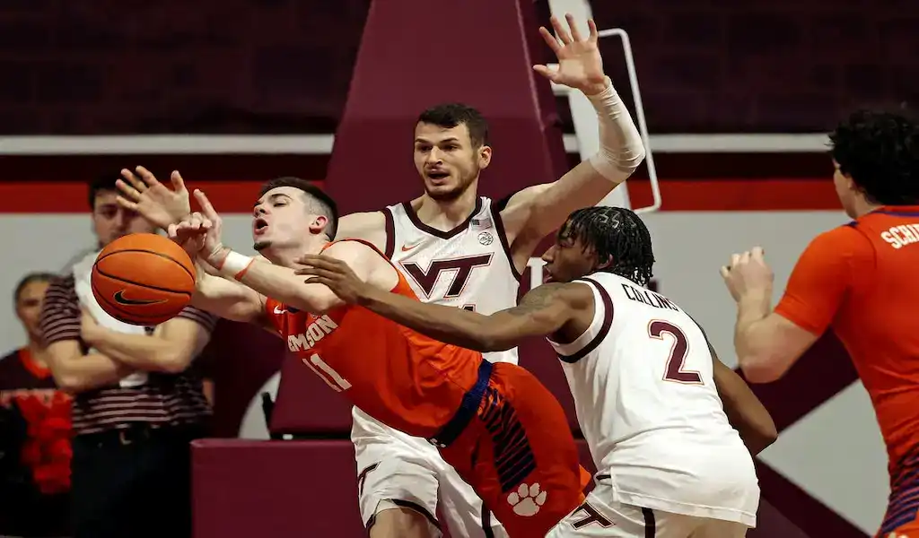 Clemson Tigers guard drives to the basket against Boston College Eagles defense during NCAA basketball action.