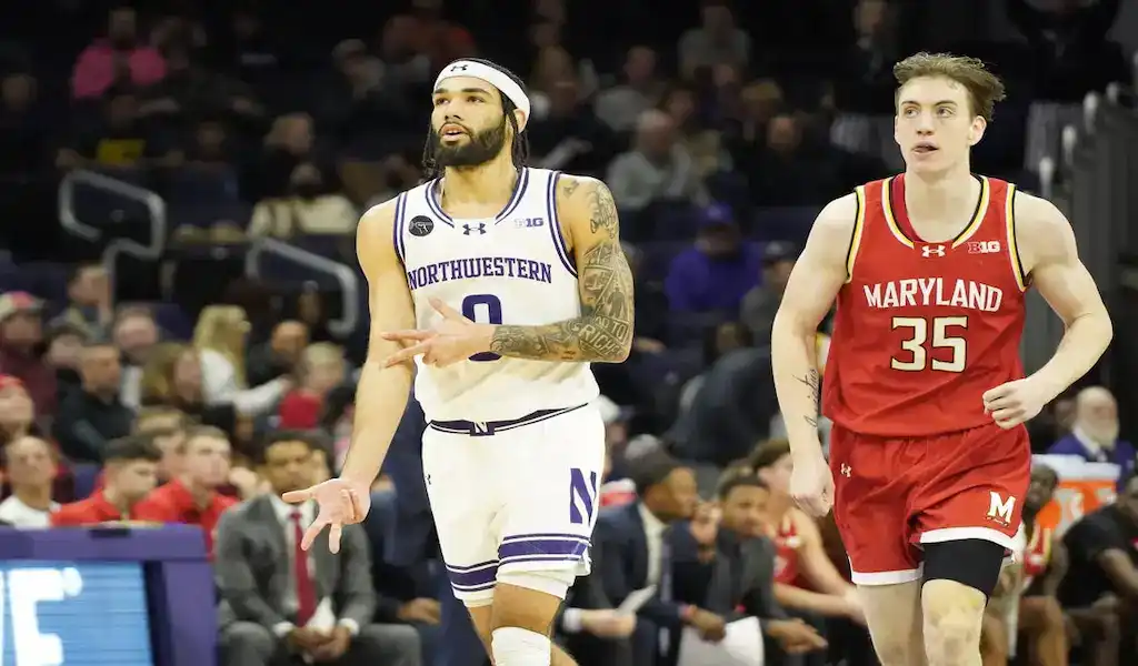 Northwestern Wildcats player dribbling past Maryland defender during a college basketball game