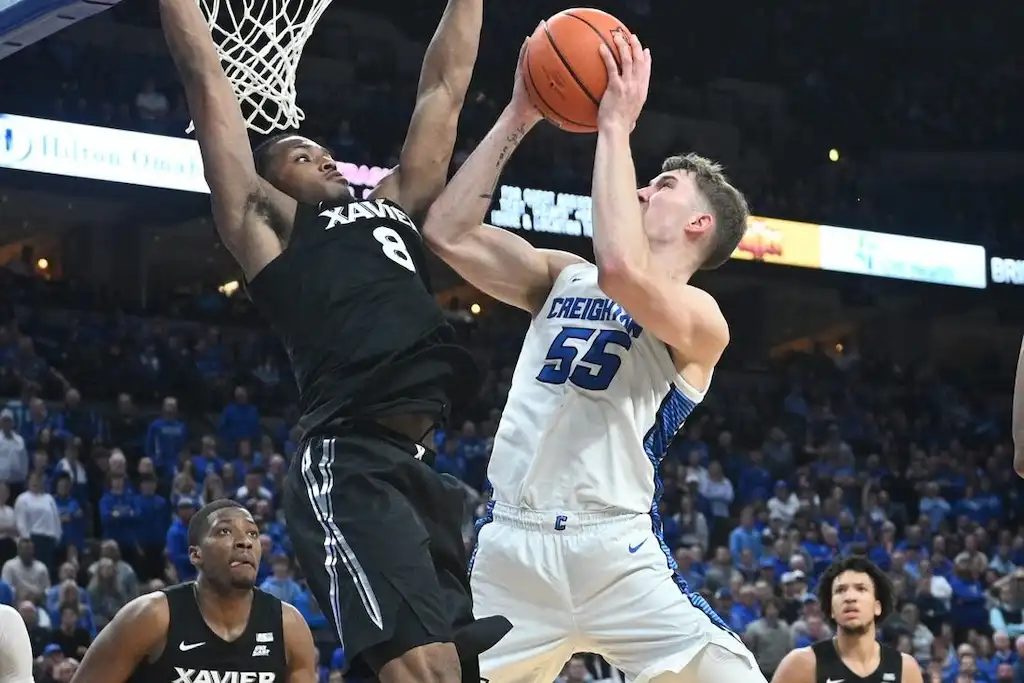 NCAAB 4 Creighton player goes up for a shot while a defender jumps to block near the rim.