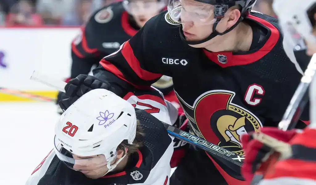 NHL 9 Ottawa Senators captain battles for position against a Calgary Flames player during an NHL game.