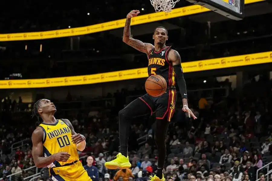 2 A basketball player from the Atlanta Hawks soars midair for a dunk while an Indiana Pacers defender looks on.