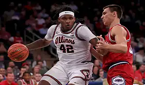 Illinois Fighting Illini player drives to the basket against Northwestern Wildcats defender during their January 2, 2024 matchup.