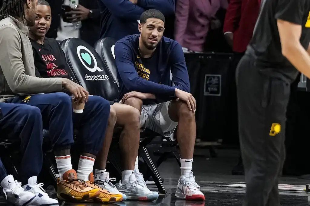 5 A group of Indiana Pacers players are seen sitting courtside on the bench during a game.