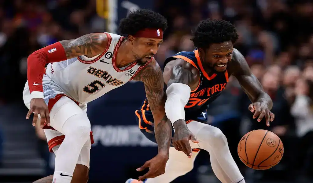 New York Knicks player battles Denver Nuggets defender for loose ball during NBA game.