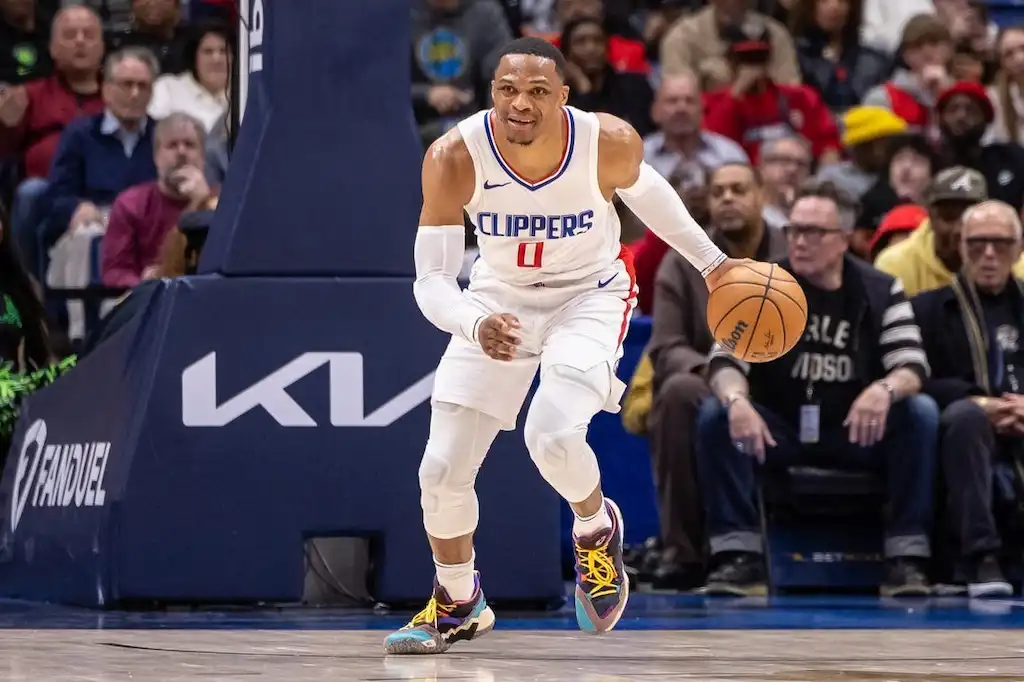 A Clippers basketball player dribbles up the court with focus during an NBA game.
