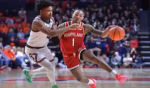 Maryland Terrapins guard drives to the basket while being defended by a Michigan State player during a college basketball game.
