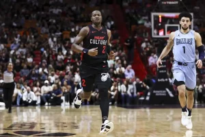 A Miami Heat player wearing a black “Heat Culture” jogs up the court.