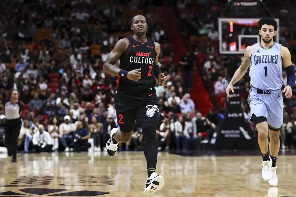 A Miami Heat player wearing a black “Heat Culture” jogs up the court.