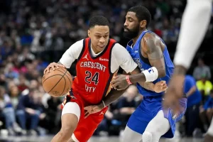 New Orleans Pelicans player drives to the basket while being closely guarded by a defender.