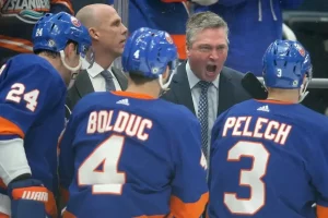 New York Islanders head coach passionately addresses players during a game.