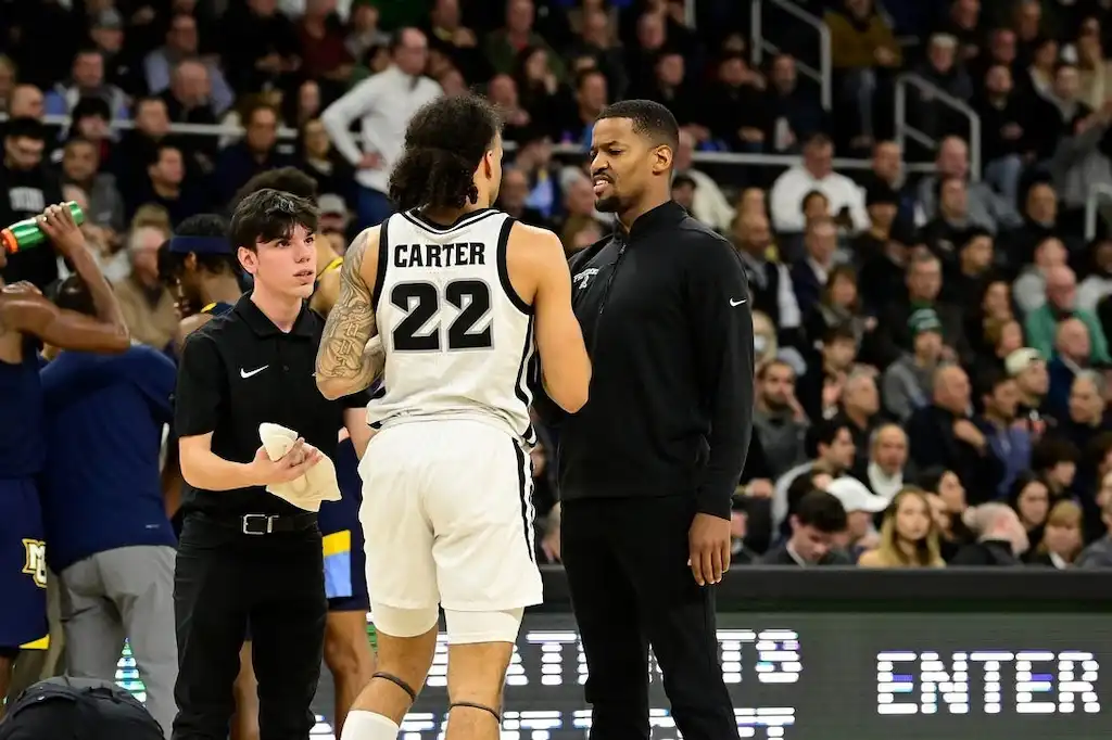 NCAAB 1 A providence basketball player has an intense conversation with a coach on the sideline.