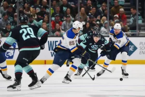 Players from the Seattle Kraken and St. Louis Blues battle for control of the puck.