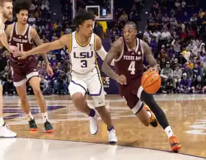 Texas A&M player drives past LSU defender during a college basketball game