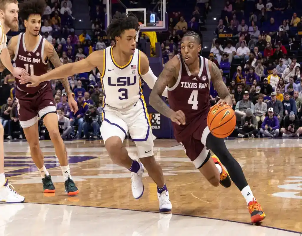 Texas A&M player drives past LSU defender during a college basketball game