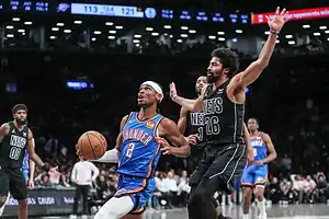 Thunder’s number 2 drives to the basket as a Nets defender attempts to block the play.