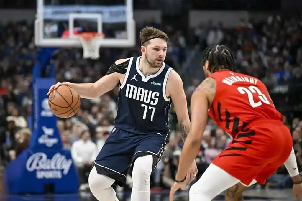 Dallas Mavericks player Luka Dončić dribbles while being defended by a Toronto Raptors player during an NBA game.