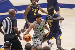 Baylor guard dribbles aggressively while being tightly defended by a West Virginia player during a college basketball game