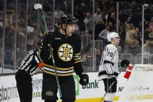 A Boston Bruins player celebrates with a loud yell after scoring a goal.