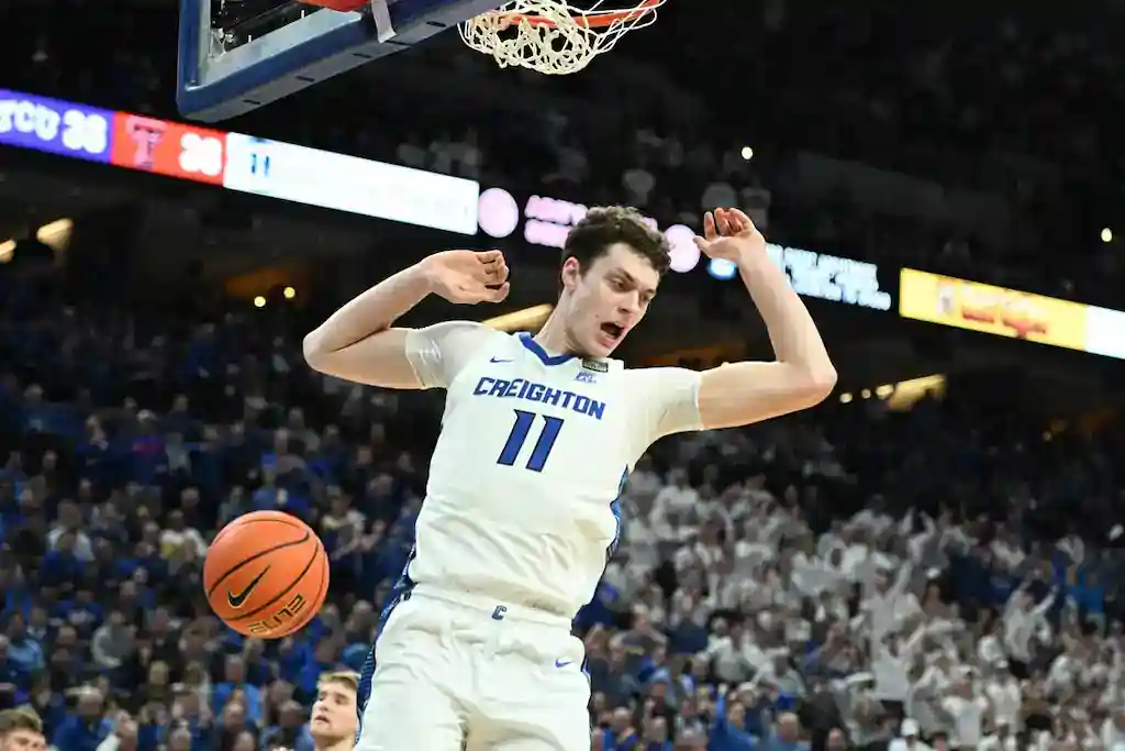 NCAAB 5 A Creighton player wearing number 11 reacts after a slam dunk during a college basketball game.