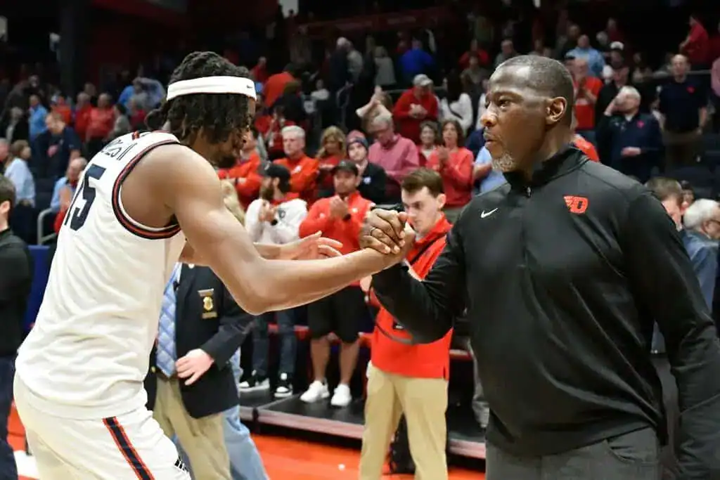 Dayton player shakes hands with coach after game.