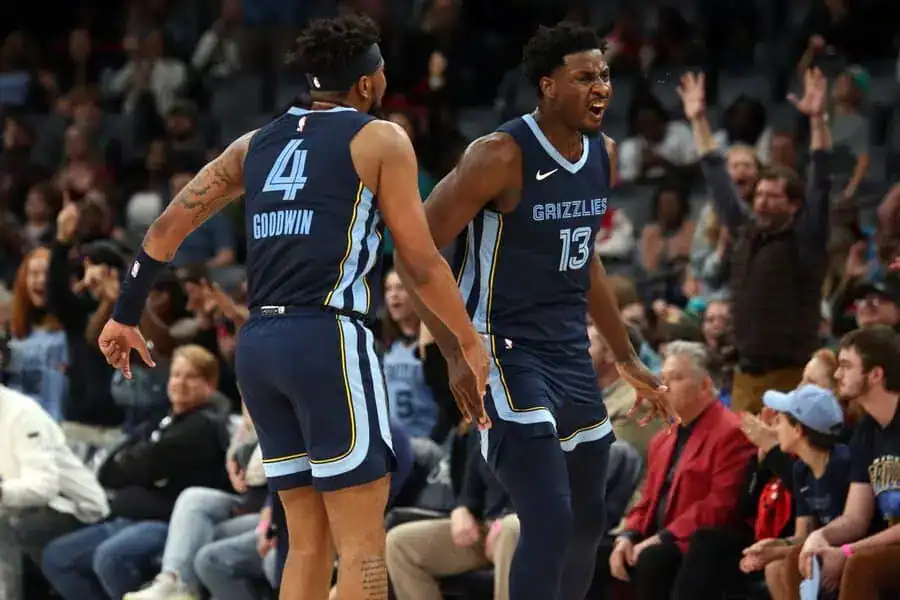 Two basketball players are joyfully celebrating together on the court after a successful play.