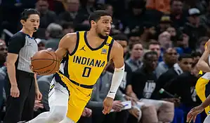 Indiana Pacers player driving with the ball during an NBA game against the Charlotte Hornets.