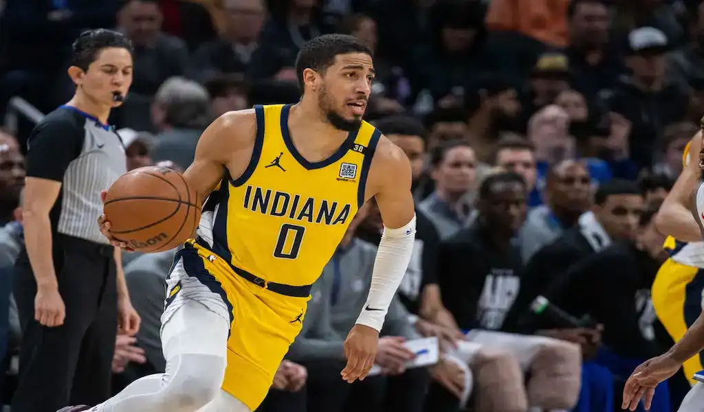 Indiana Pacers player driving with the ball during an NBA game against the Charlotte Hornets.