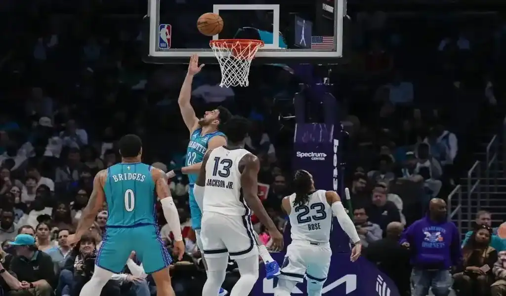 5 Charlotte Hornets player attempts a layup against Indiana Pacers defenders during an NBA game.