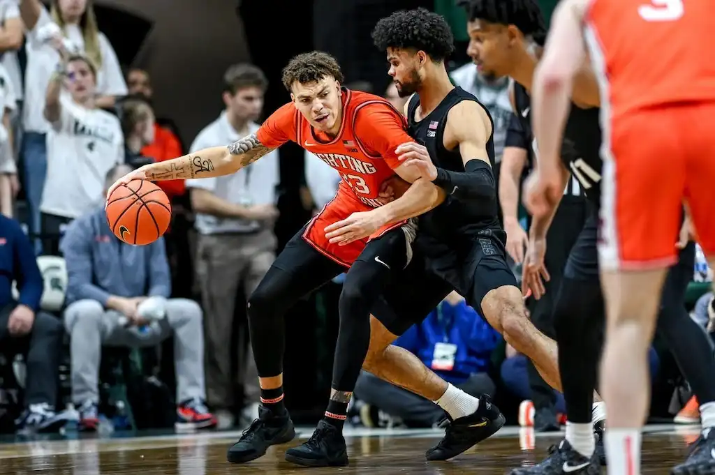 NCAAB 6 Illinois player attempts to drive past a defender in during a tightly contested game.