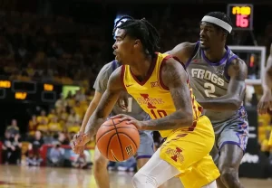 Iowa State basketball player drives toward the basket while being closely defended by a TCU player.