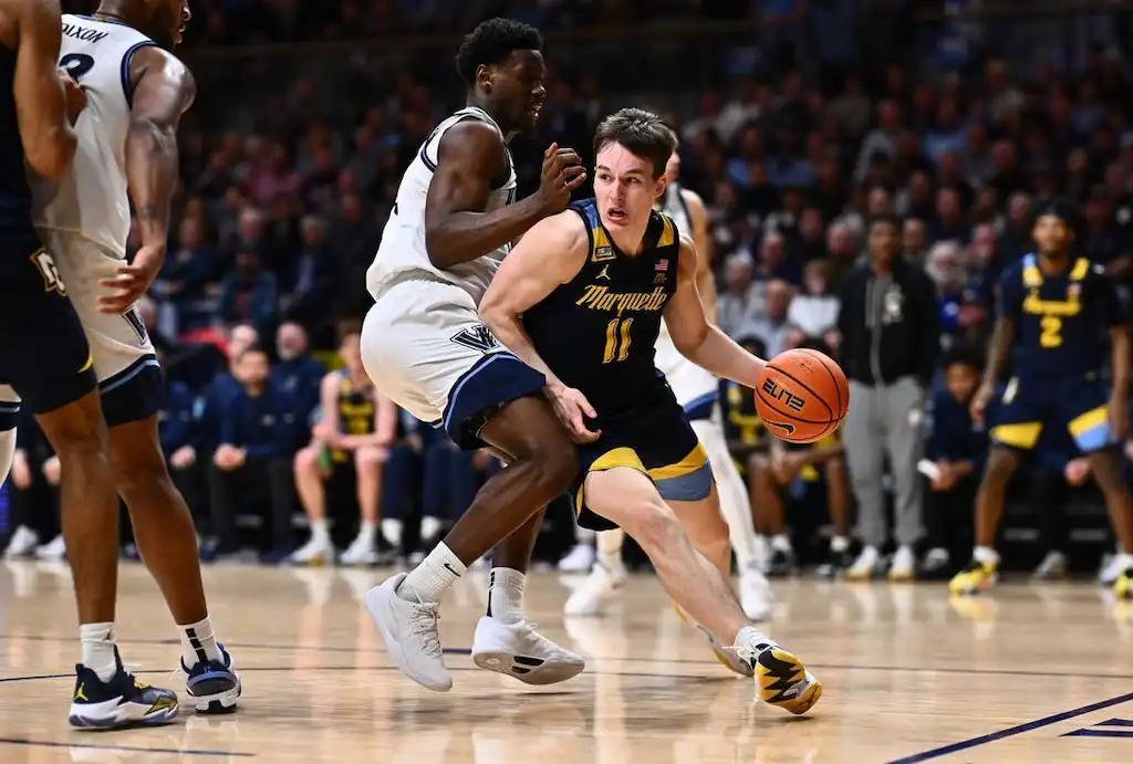 A Marquette player wearing jersey number 11 drives past a defender.