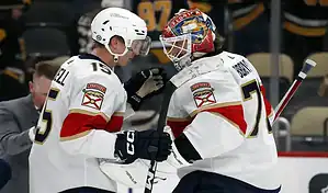 Florida Panthers players celebrating together on the ice during an NHL game.