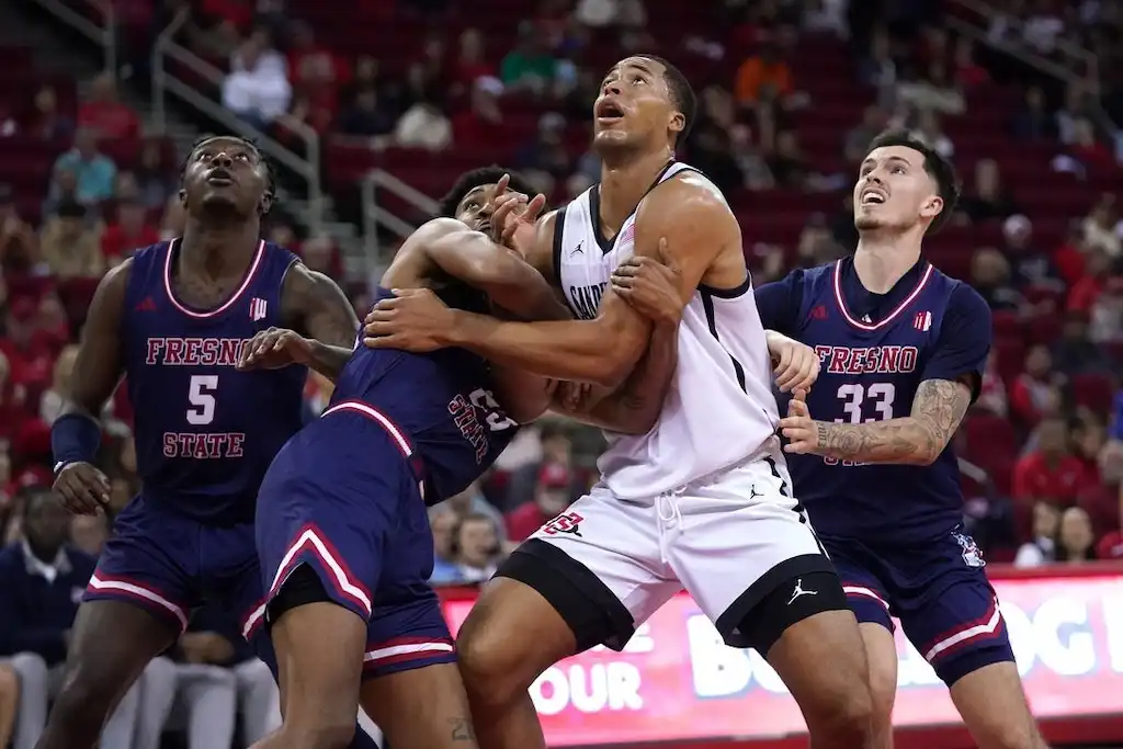 NCAAB 4 Players from San Diego State and another team fight for rebounding position under the basket.