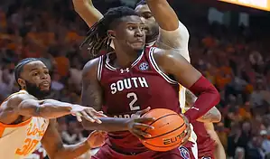 South Carolina Gamecocks player drives with the ball against Mississippi Rebels defense in NCAA basketball game.