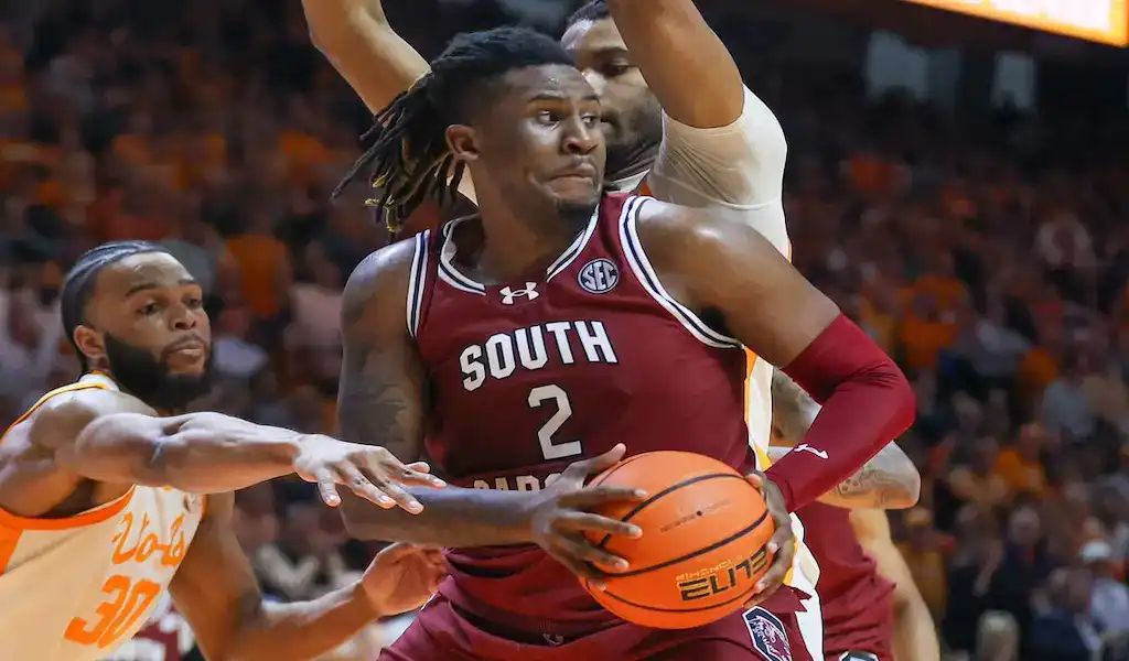 South Carolina Gamecocks player drives with the ball against Mississippi Rebels defense in NCAA basketball game.