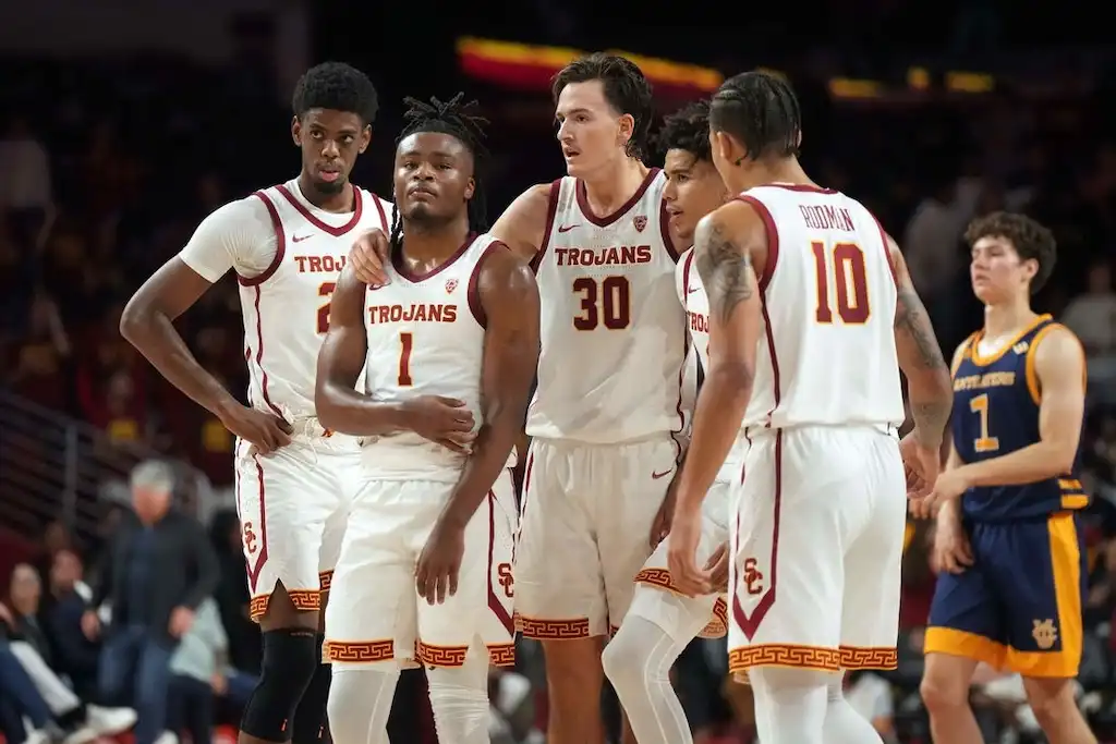 NCAAB 1 USC basketball players huddle on the court.