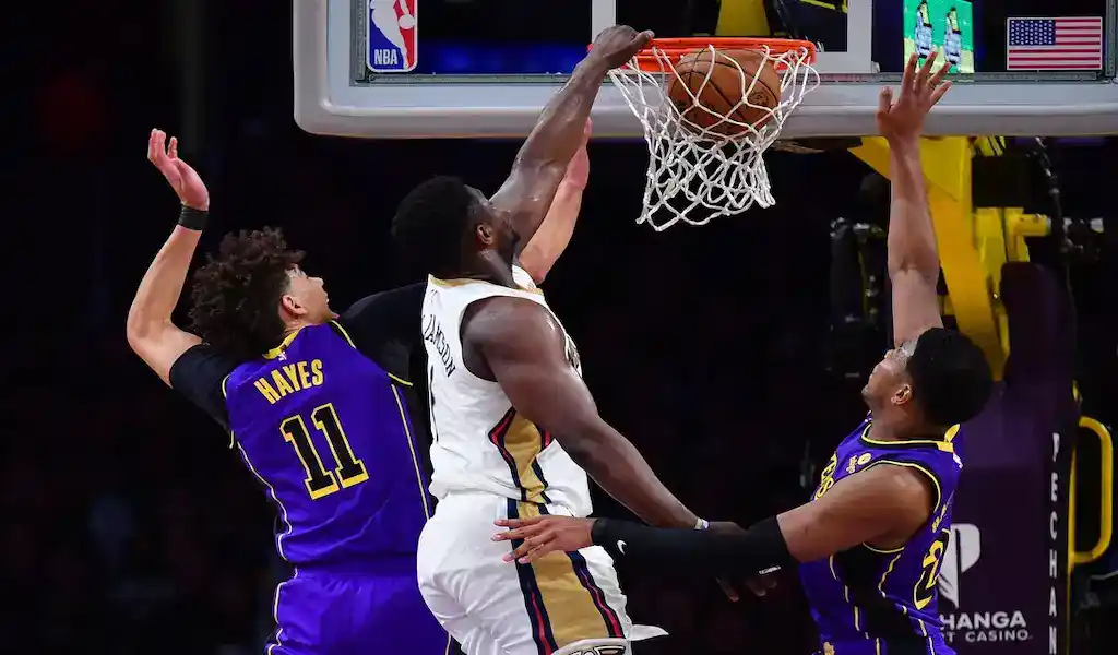 New Orleans Pelicans player Zion Williamson scores a basket while being defended by the Portland Trail Blazers during a February 10, 2024, NBA game.