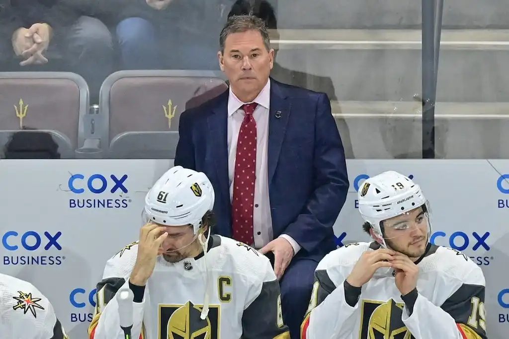 Vegas Golden Knights coach stands behind the bench with players.