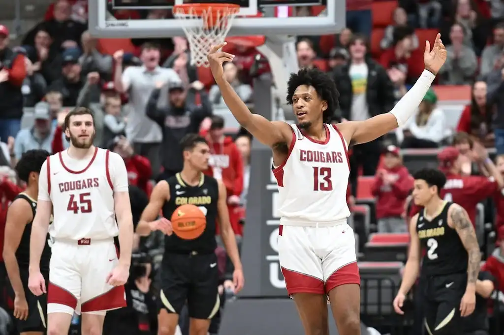 NCAAB 7 A Washington State basketball player raises his arms in celebration.
